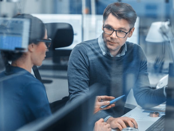 Female-Project-Supervisor-Talks-to-a-Male-Industrial-Engineer-who-Works-on-Personal-Computer-1